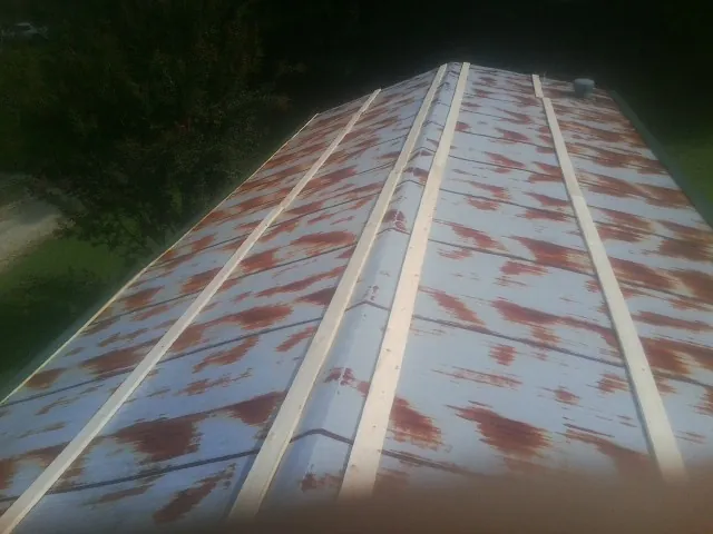 Rusted metal roof panels with new wood purlins before replacement — Storm Damage Roof Repair in Saint Hedwig by Roofing Brothers