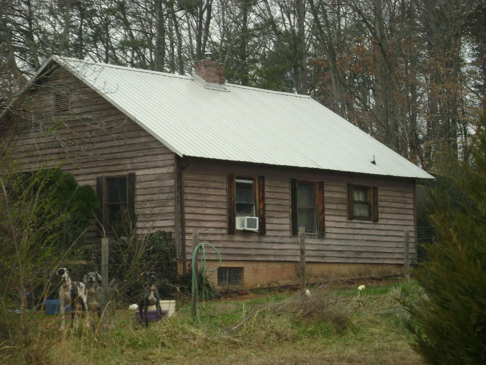 White metal roof on an old wood sided farmhouse, from a Metal Roof Installation job in Saint Hedwig